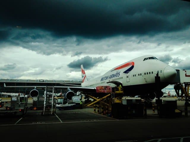 British Airways Boeing 747 being loaded on the ramp being loaded with cargo for take-off.